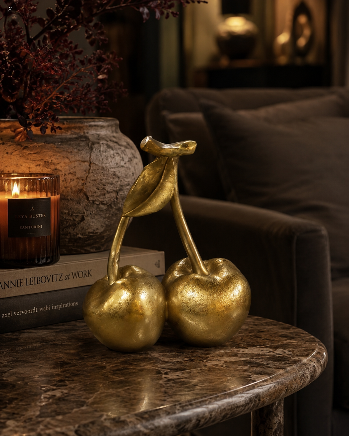 Gold resin cherry ornament adding a playful accent to an interior.