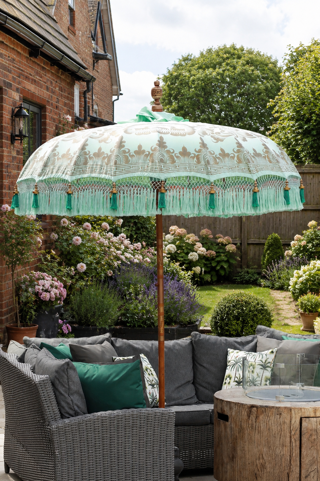 Riviera Mint handmade Balinese-style garden parasol styled with grey rattan patio seating in an English garden
