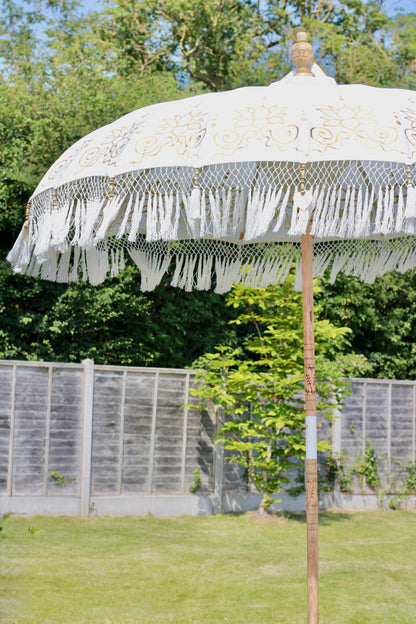 Gold and white garden parasol with carved wooden pole and decorative handmade details