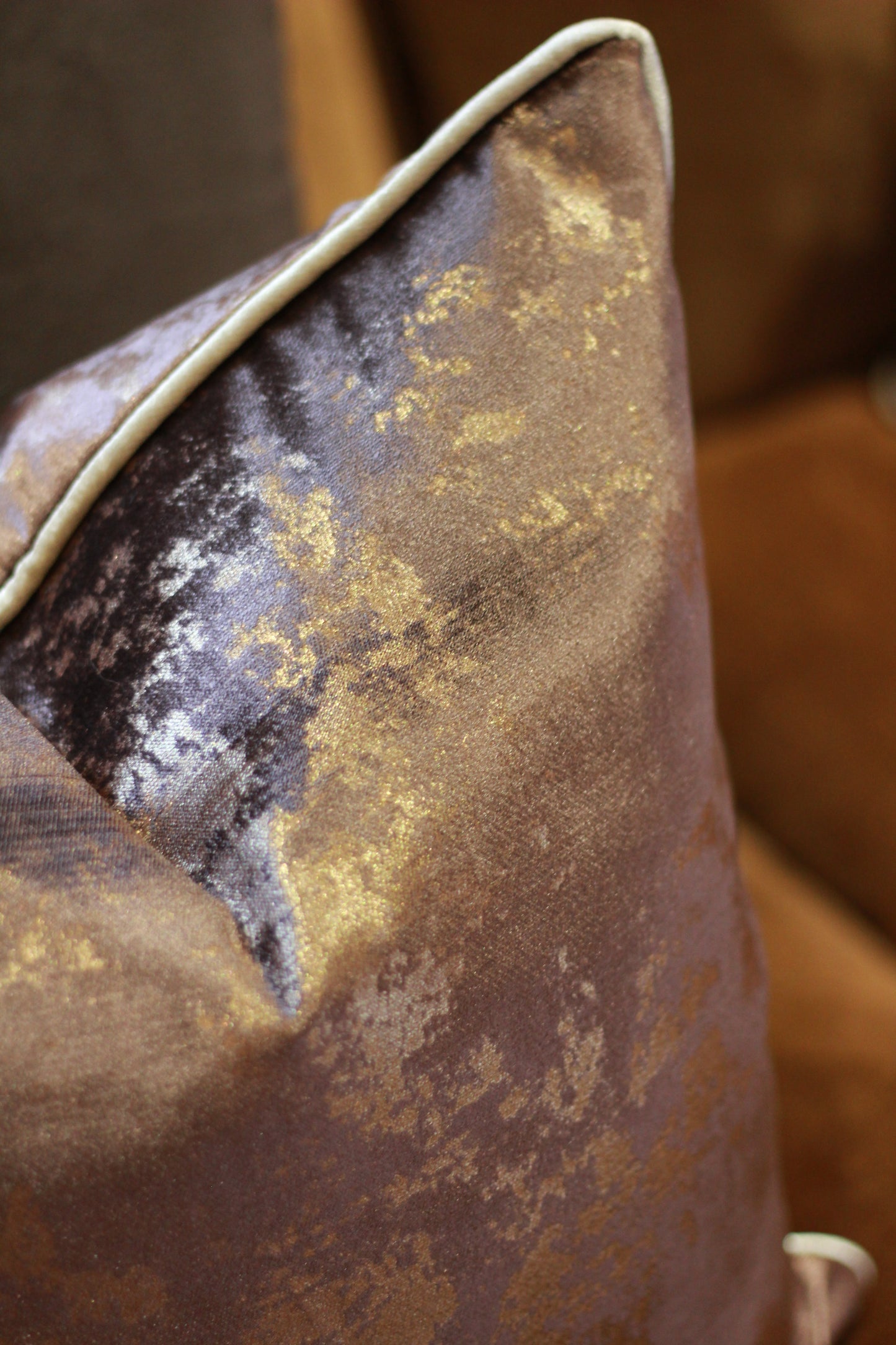 Detailed velvet texture and bronze-toned metallic flecks on chocolate cushion.