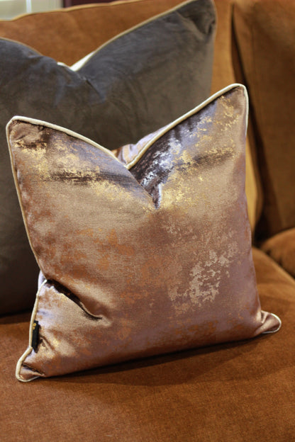 Close-up of the shimmering metallic finish on the chocolate velvet cushion.