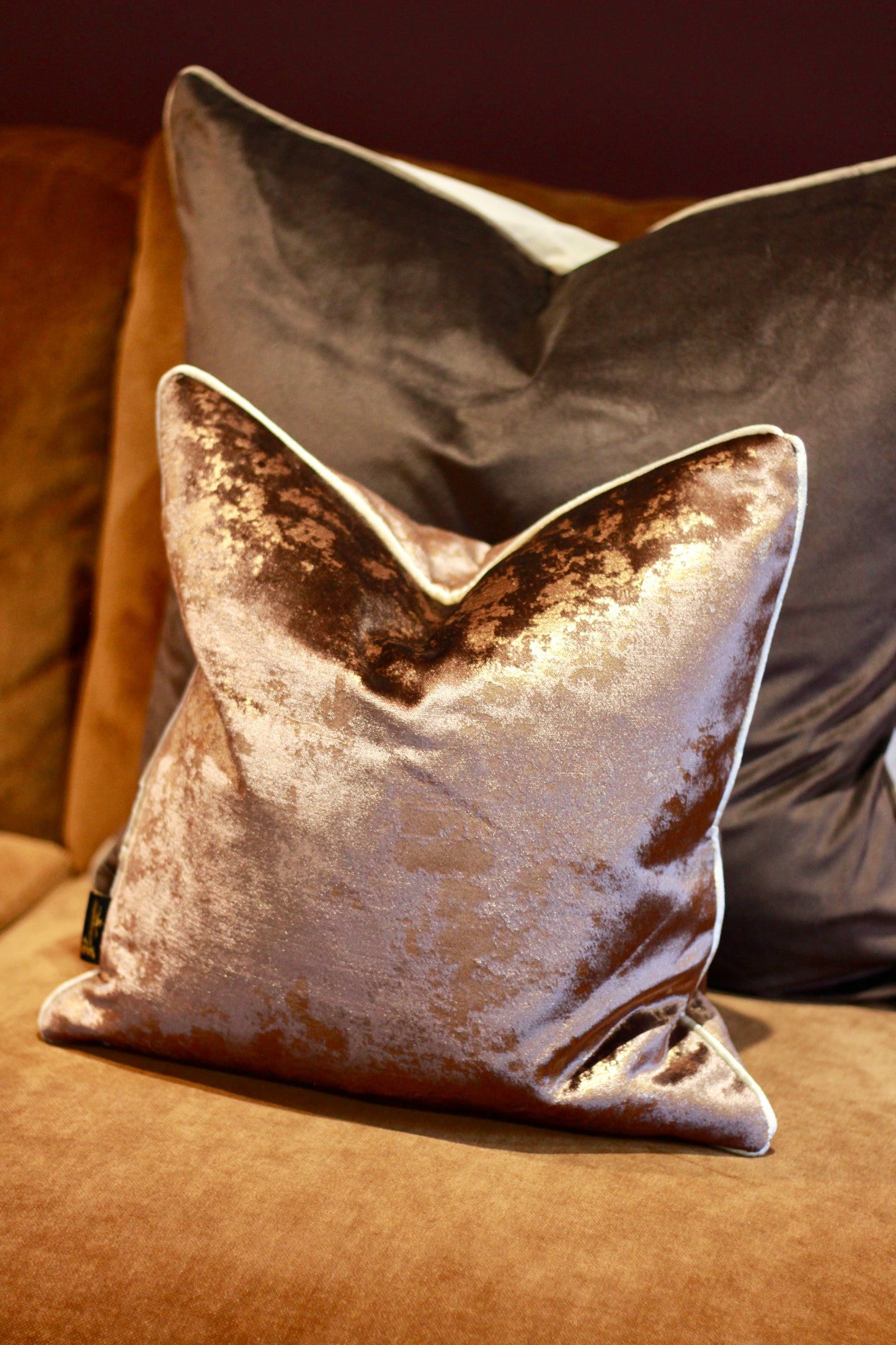 Chocolate velvet feather cushion styled in a warm neutral interior.