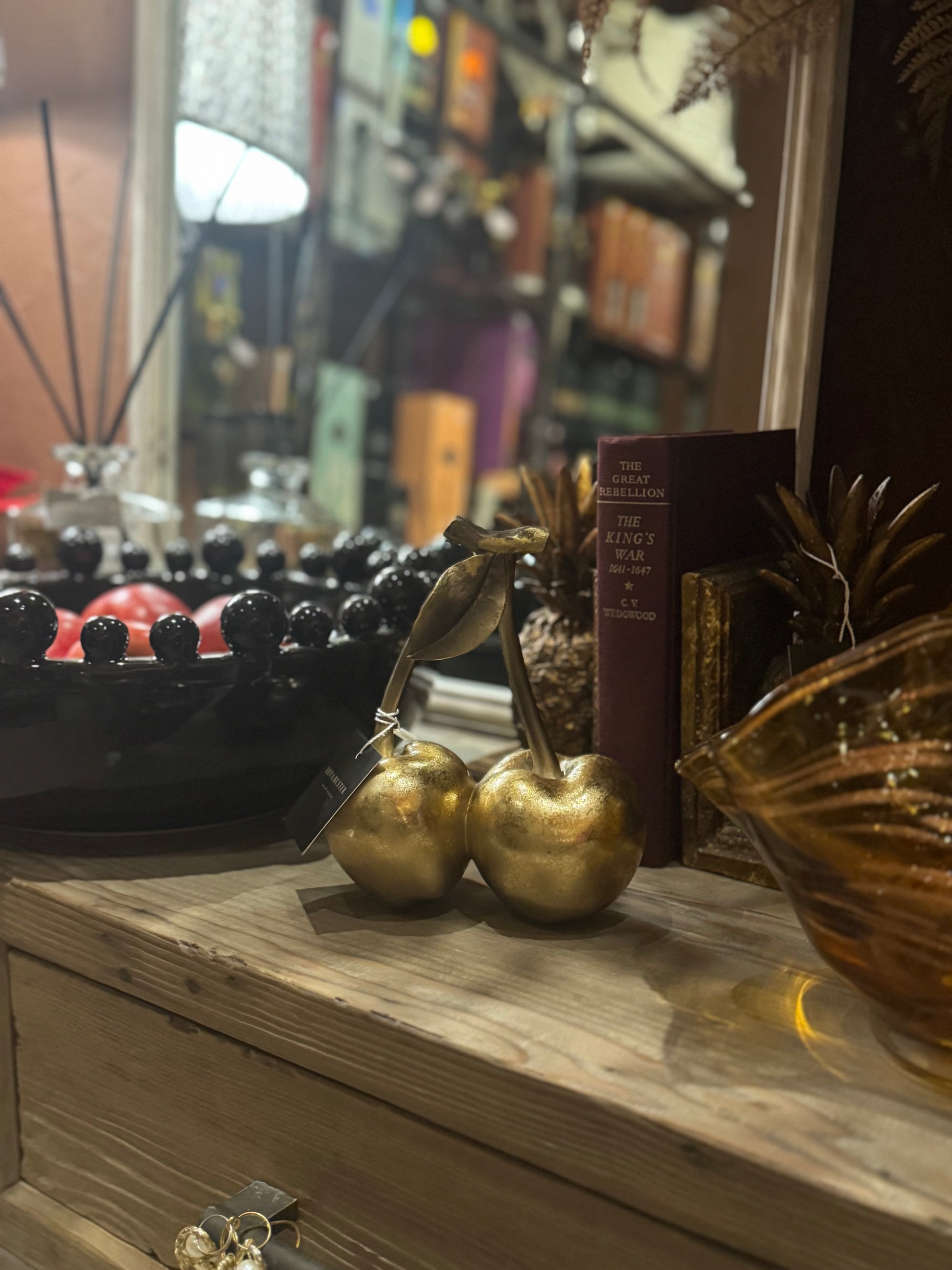 Decorative gold resin cherries ornament shown from the front.