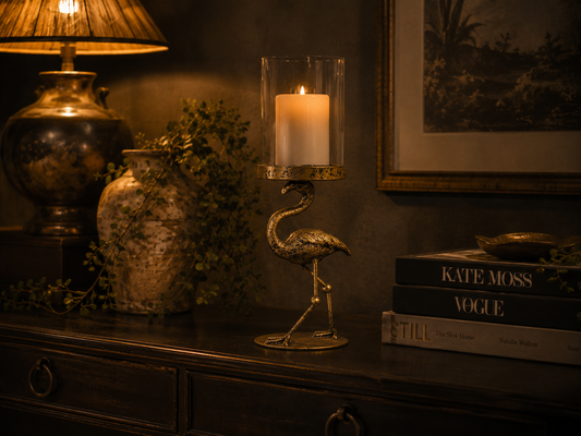 Decorative metal flamingo candle holder with a clear glass candle cylinder.