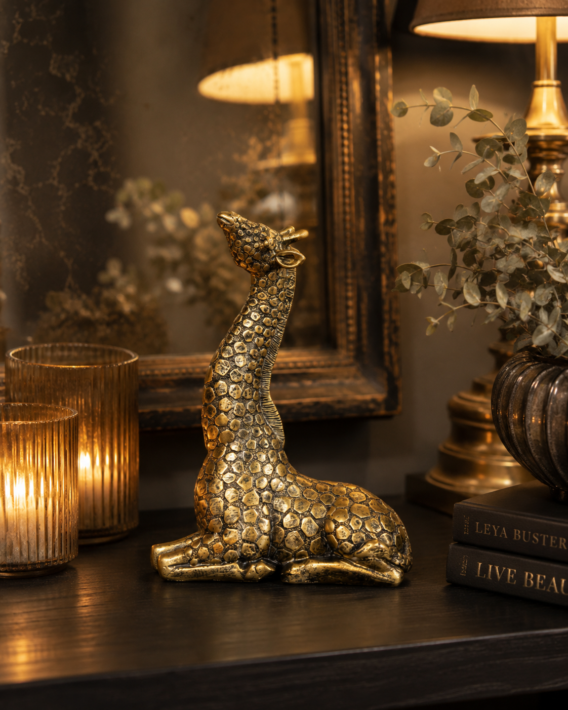 Decorative gold giraffe styled on a shelf in a curated interior.