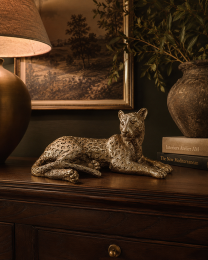 Gold laying leopard decoration styled as a statement accent in an elegant interior.