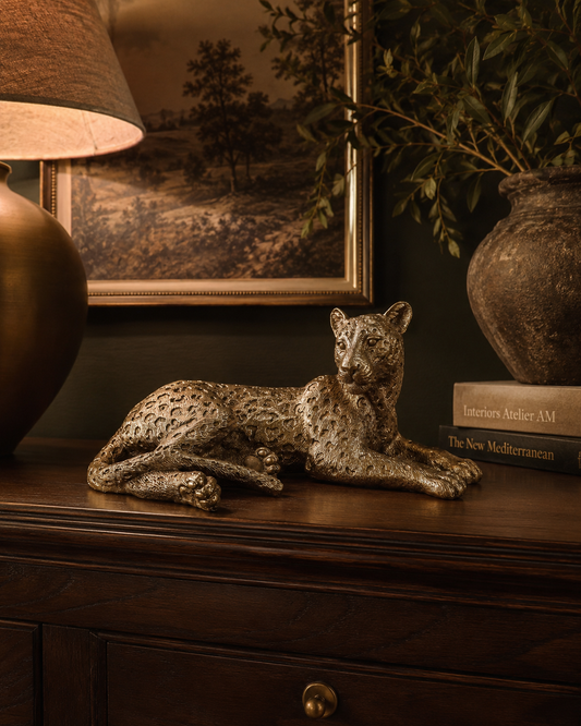 Gold laying leopard decoration styled as a statement accent in an elegant interior.