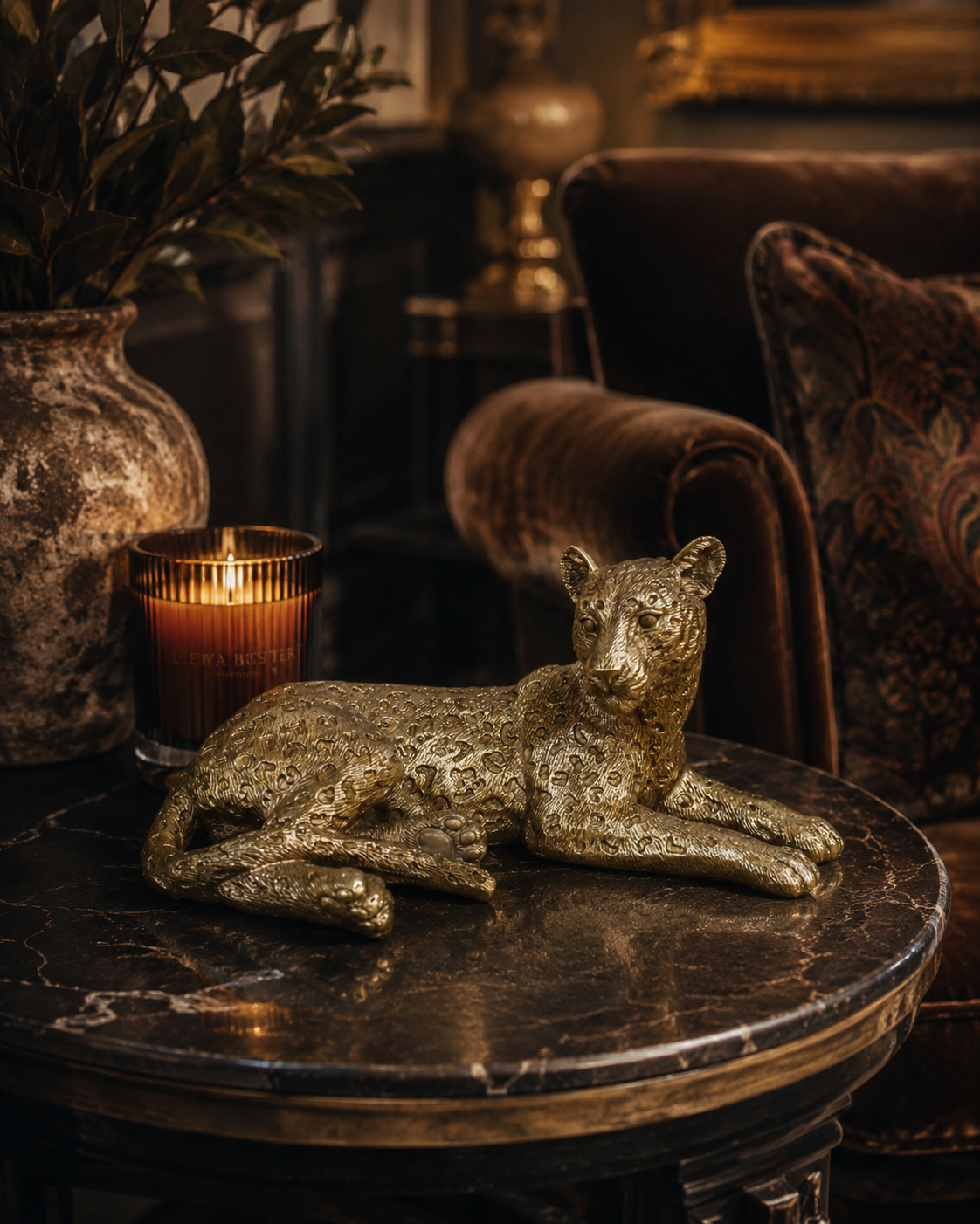 Gold resin leopard ornament displayed with layered home accessories.