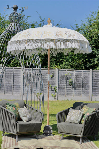 Gold and white fringed Balinese-style parasol as statement garden decor