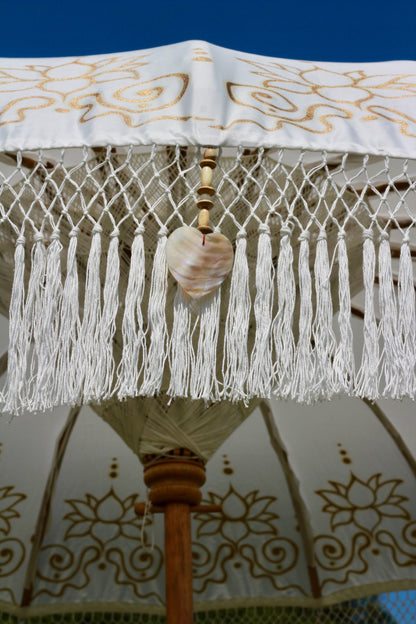 Statement white and gold garden parasol with ornate detailing for luxury outdoor styling