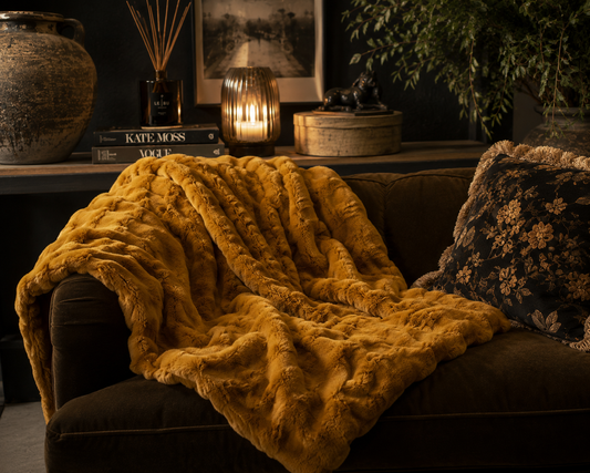 Whiskey brown faux fur ruffle throw styled in a warm neutral living room.