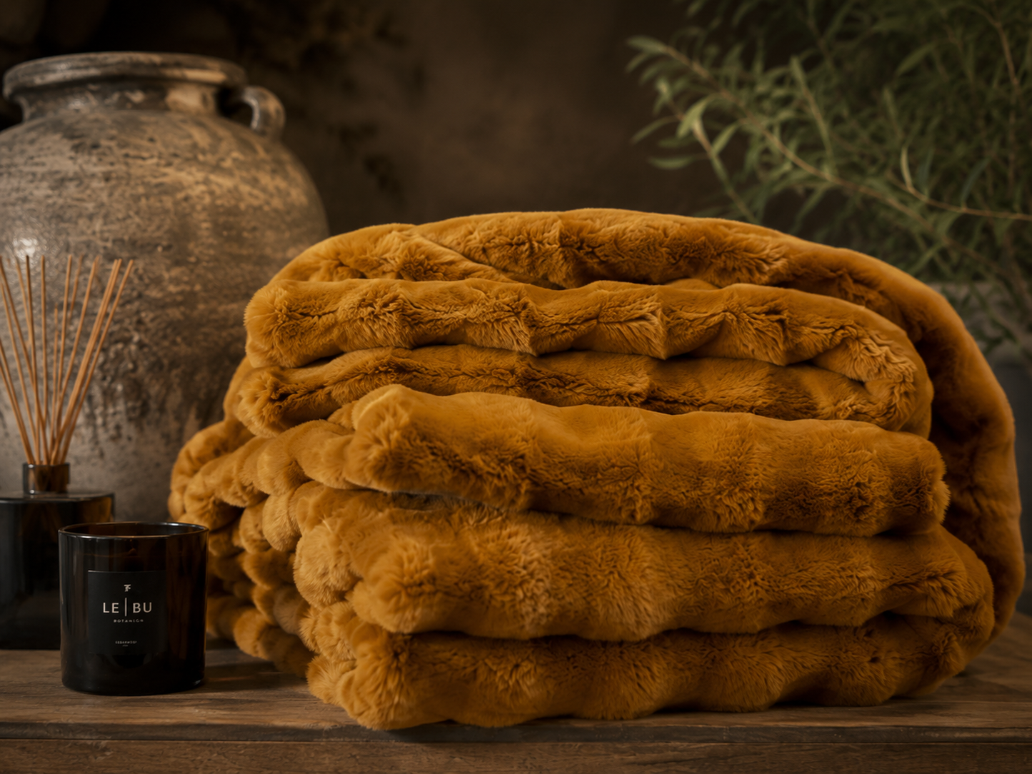 Large whiskey brown faux fur ruffle throw styled in a cosy layered interior.