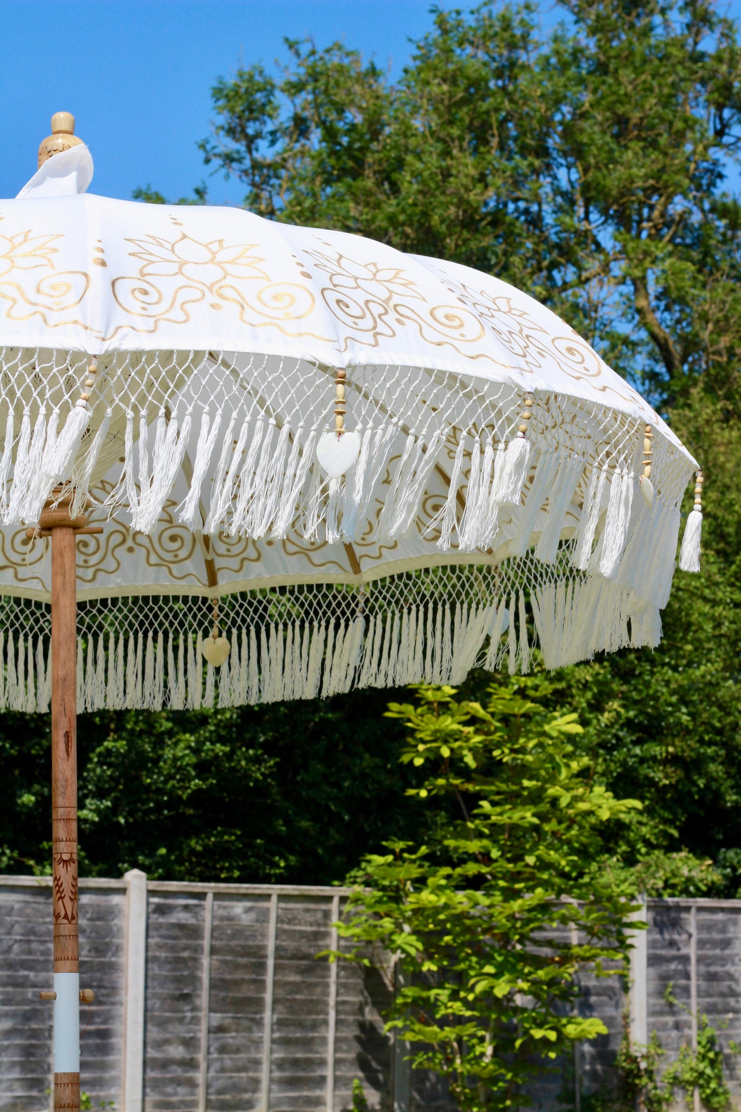 Gold and white handmade garden parasol showing decorative hand painted canopy detail