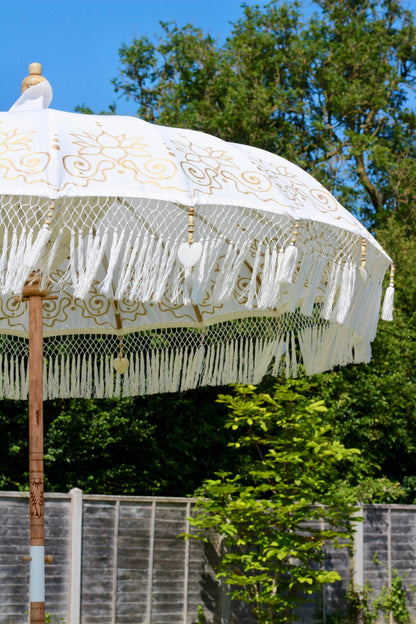 Gold and white handmade garden parasol showing decorative hand painted canopy detail
